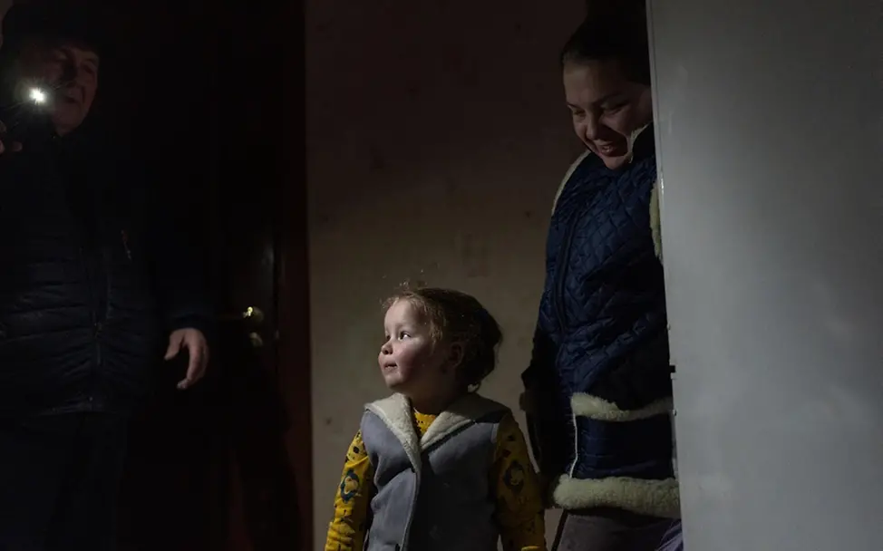 Ukraine Krieg: Dasha (3) steht warm eingepackt neben ihrer Mutter Iryna in der Wohnung.