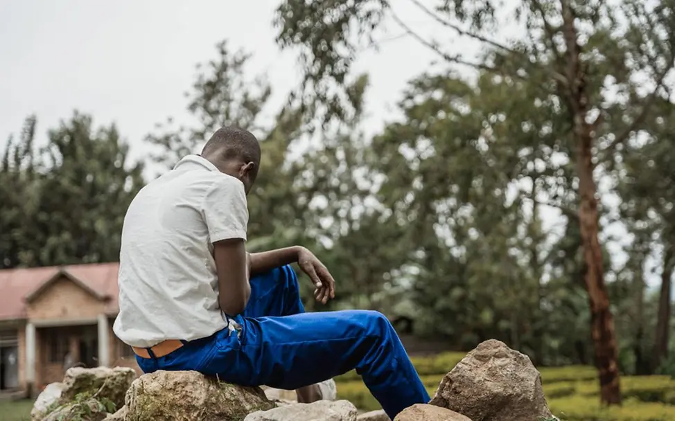 Kindersoldaten: Ein Jugendlicher vor einem Gebäude.