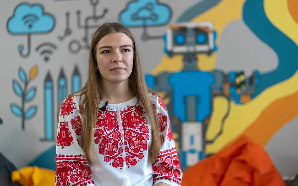 Jugendliche mit rot-weißer Bluse posiert für ein Foto.