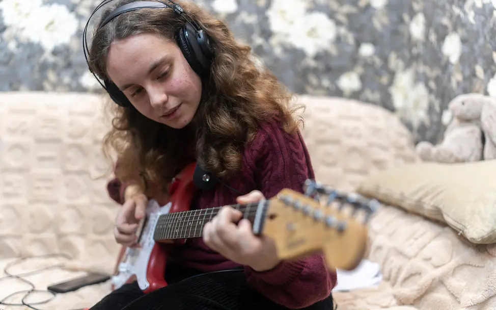 Jugendliche spielt auf Gitarre.