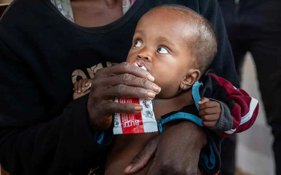 Madagaskar Hungerkrise: Ein Baby wird auf dem Arm seiner Mutter mit Ersnusspaste gefüttert.