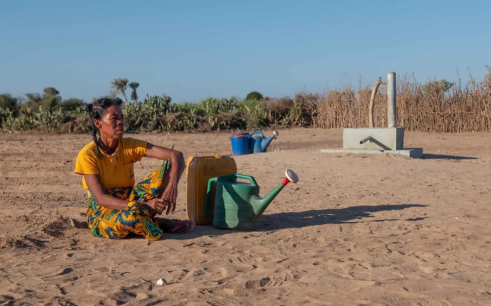 Madagaskar Hungerkrise: Eine Frau sitzt auf vertrocknetem Ackerland.