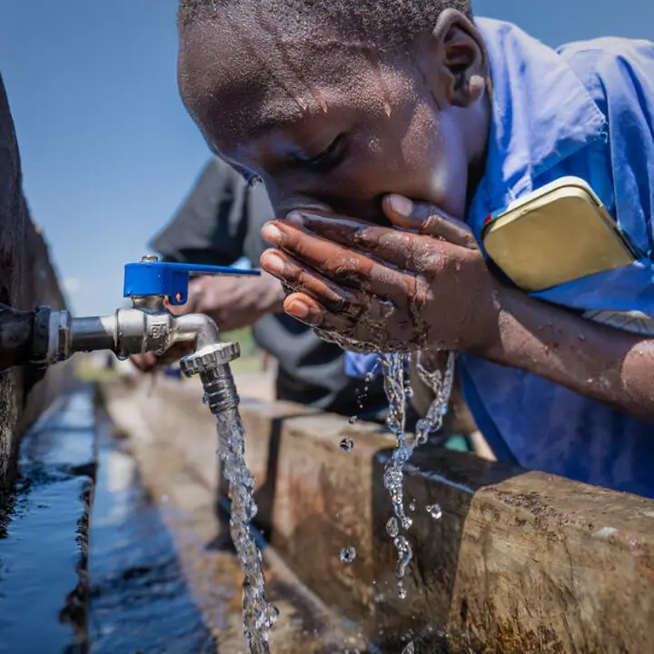 Sauberes Wasser: Ein Junge in Uganda trinkt aus einer Wasserleitung.