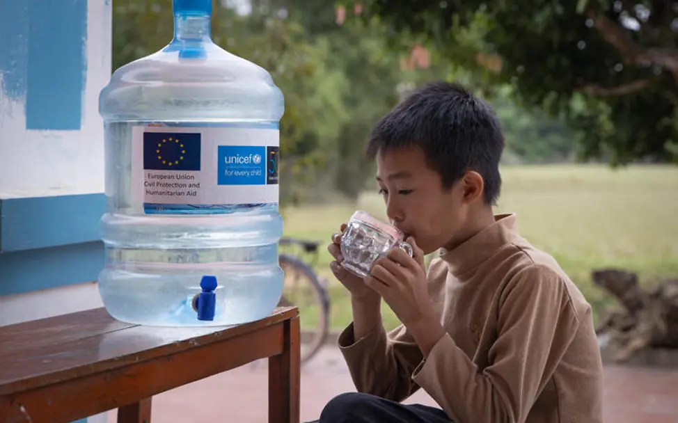 Sauberes Wasser: Ein Junge trinkt ein Glas Wasser aus einem UNICEF-Kanister.