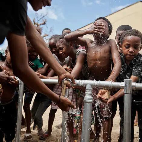 Wasserknappheit weltweit: Kinder drängen sich um eine Wasserstelle