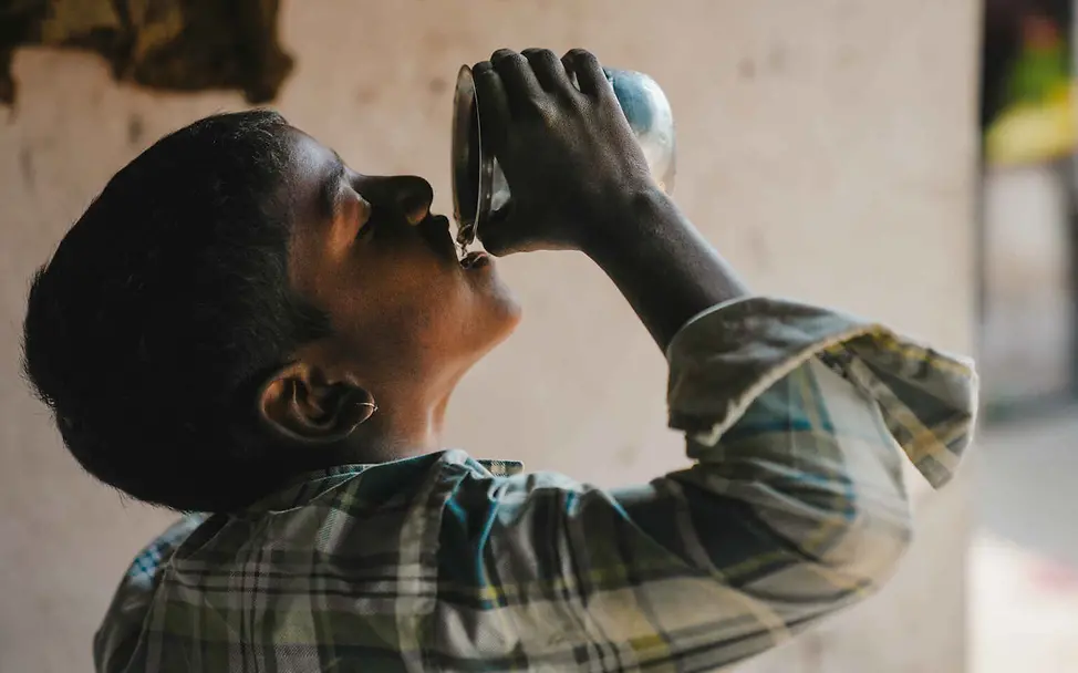 Wasserknappheit weltweit: Ein Junge trinkt Wasser aus einem Becher.