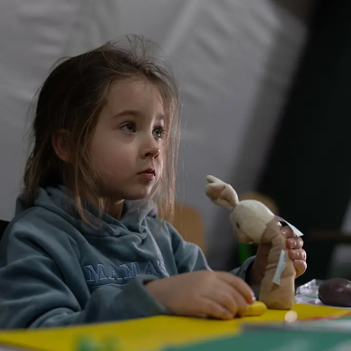 Ukraine Krieg: Ein Mädchen in Kyjiw sitzt in einem Schutzzelt und spielt. 