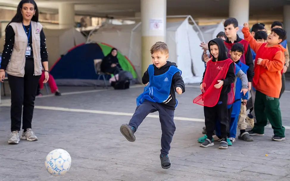 Leben im Libanon: Kinder lachen und spielen in einer Notunterkunft Fußball.