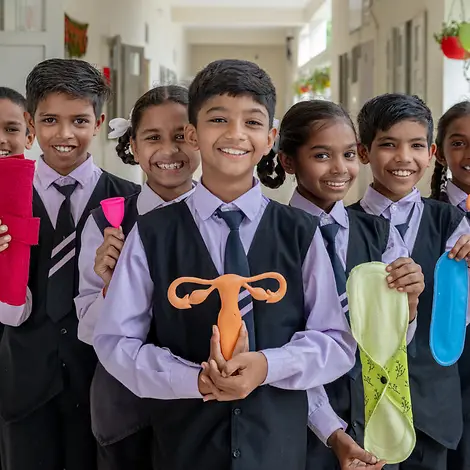 Was ist Periodenarmut: Schülerinnen und Schüler in Indien posieren mit Menstruationsprodukten.