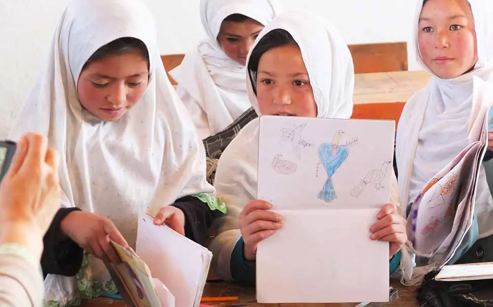 Mädchen sollen in der Schule die gleichen Chancen bekommen wie Jungen | © UNICEF/Findel Afghanistan: Mädchen zeigen auf ihren Bildern, was sie gemalt haben.